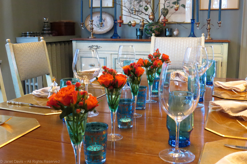 Orange sweetheart roses lined up with candles on my December table.